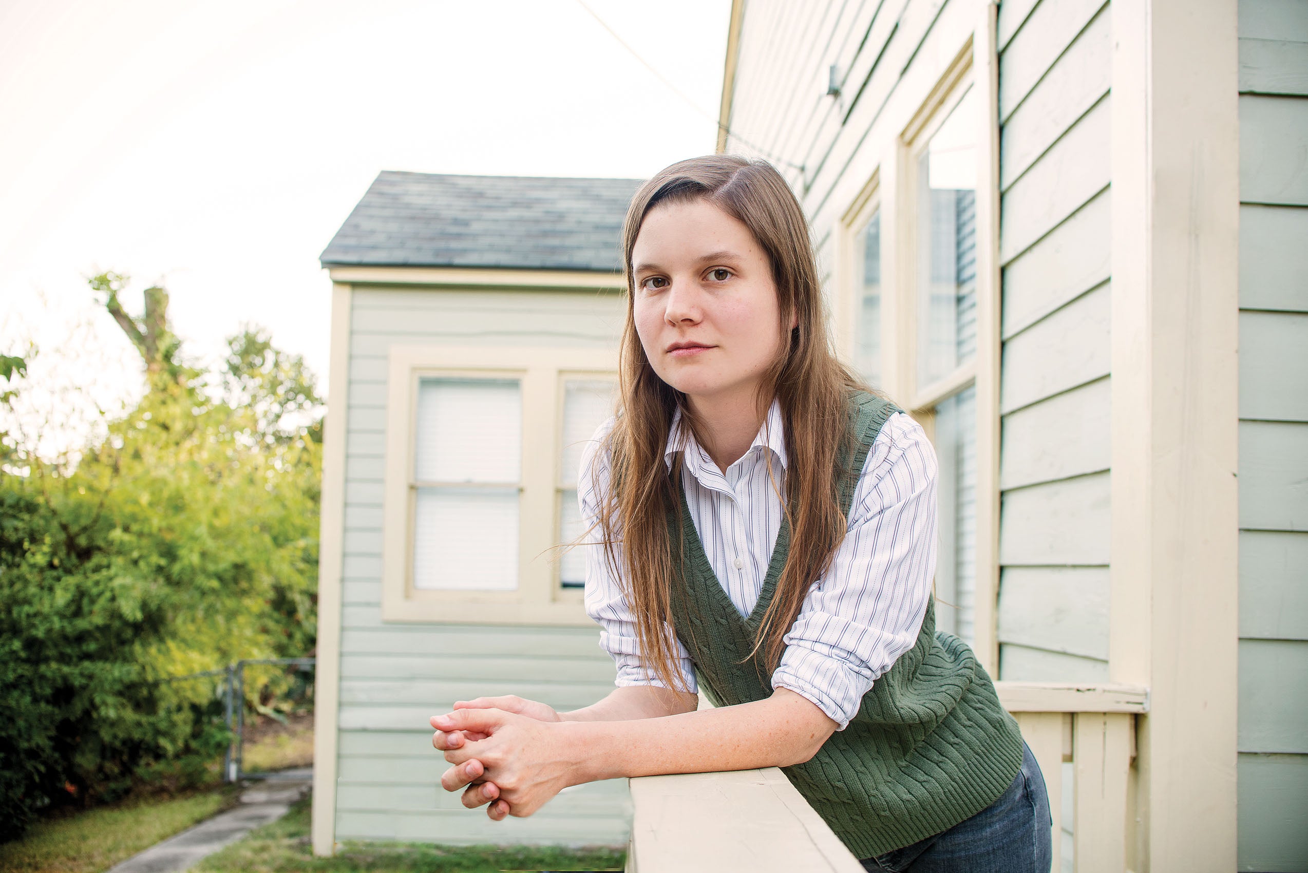 Photograph of Brianna Rennix '18 outside leaning on a porch ledge.